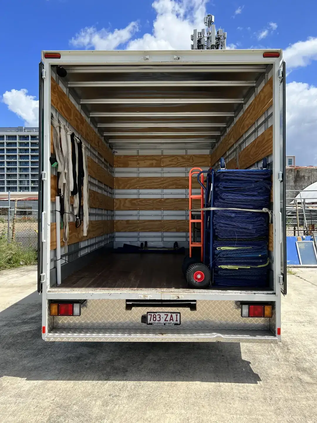 Open Ben Moves Brisbane truck with stacked protective blankets, trolleys and loading ramp