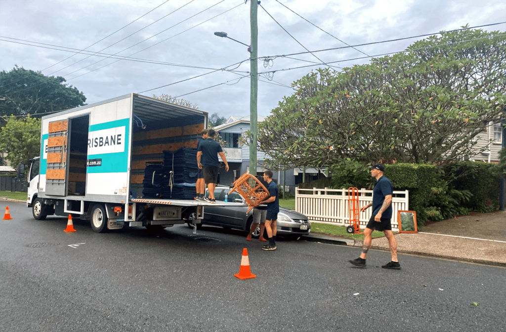 Four removalists unpacking a moving truck
